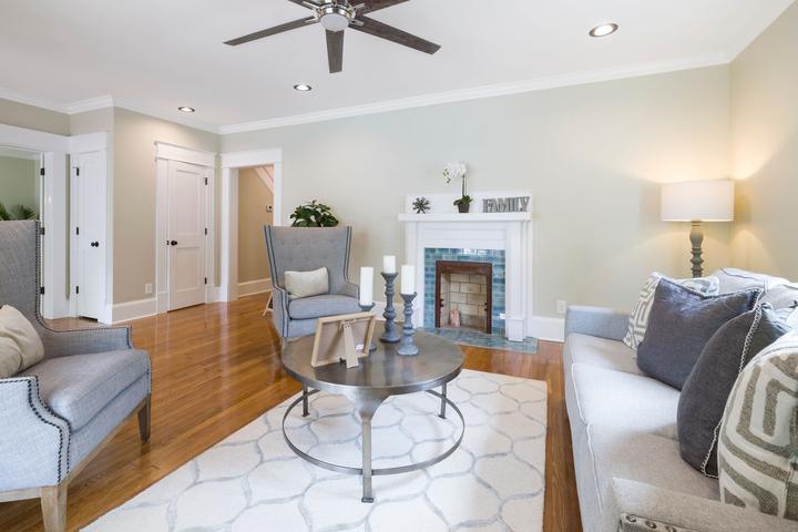 Living room with pale seating and a fireplace on the far wall